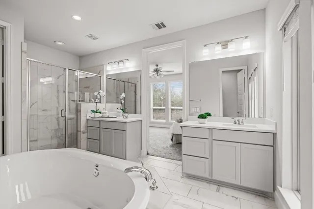 a bathroom with a tub sink shower and mirror