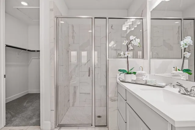 a bathroom with a granite countertop sink a mirror and a shower