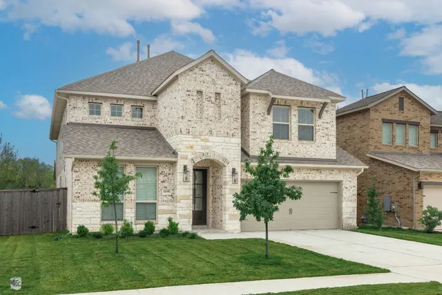 a front view of a house with a yard and garage