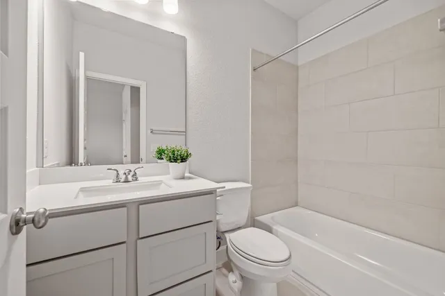 a bathroom with a sink toilet vanity and tub