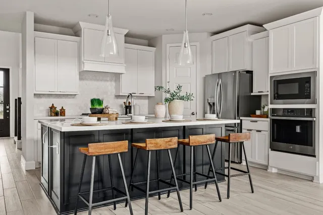 a kitchen with granite countertop a table chairs microwave and cabinets
