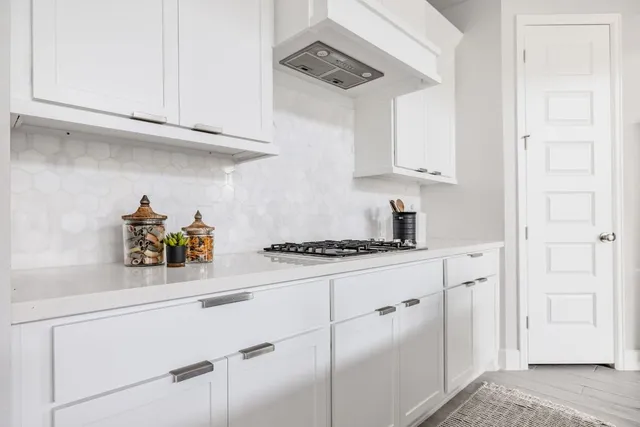a kitchen with stainless steel appliances granite countertop white cabinets and a stove