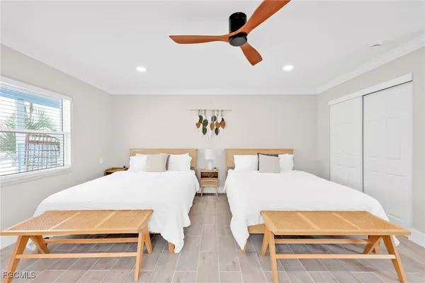 a bedroom with two beds and a ceiling fan