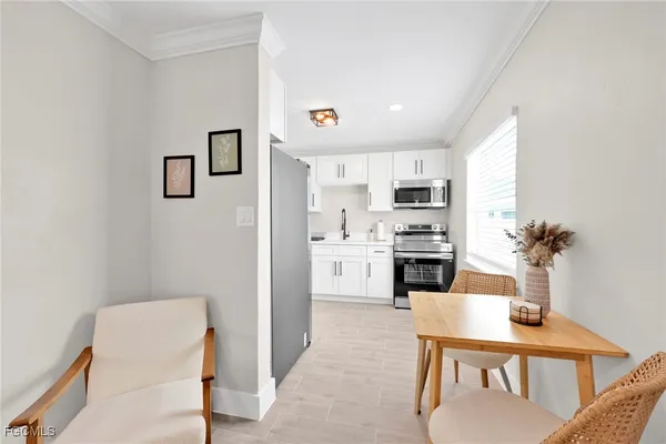 a kitchen with white cabinets and appliances