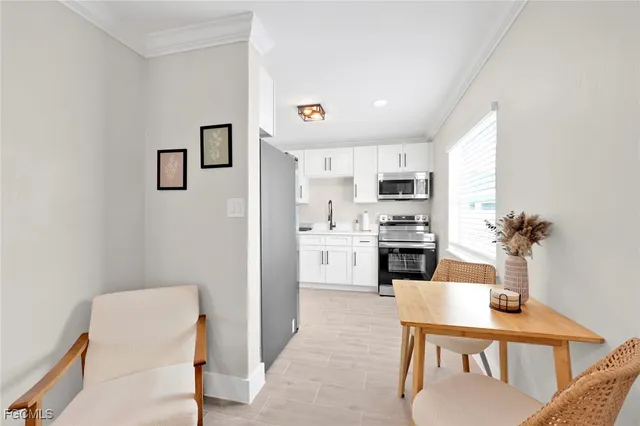 a kitchen with white cabinets and appliances