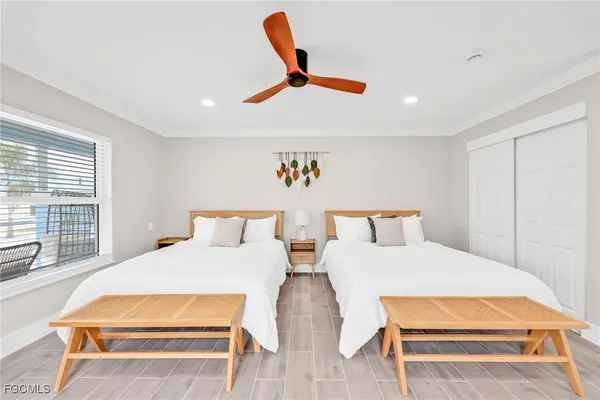 a bedroom with two beds and a ceiling fan