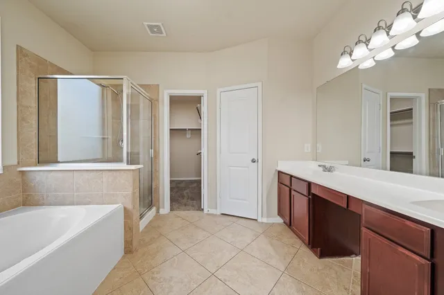 a bathroom with a tub a sink and a mirror