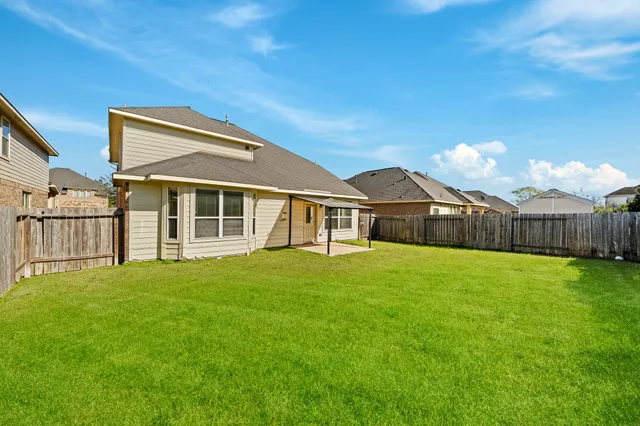 a view of a house with a yard and wooden fence