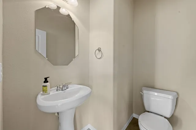 a bathroom with a toilet sink and mirror