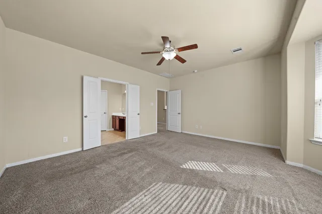 a view of empty room with ceiling fan
