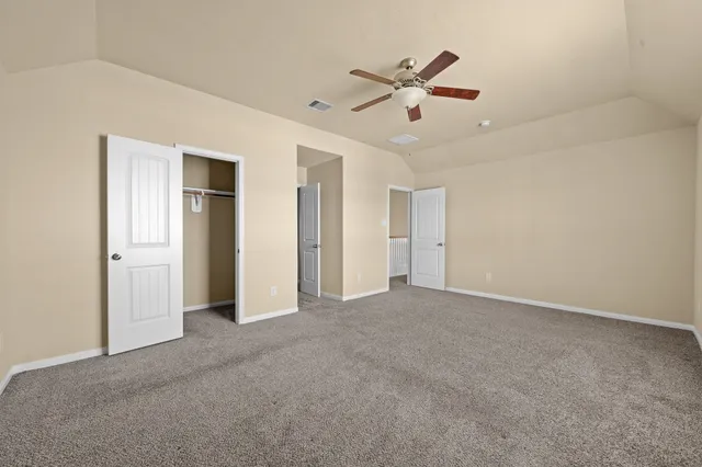 a view of an empty room and a ceiling fan