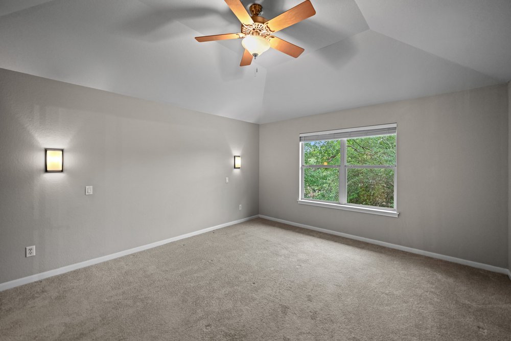 2823 Lantana Ridge Drive Austin, TX 78732 - Photo 19 of 34 an empty room with windows and fan