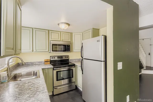 a white kitchen with stainless steel appliances and white cabinets