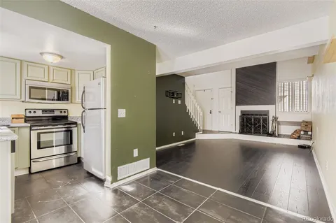 a view of a kitchen with a sink stove fridge and empty room