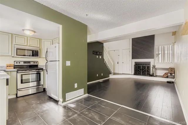 a view of a kitchen with a sink stove fridge and empty room