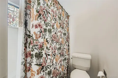 a white toilet sitting next to a shower curtain