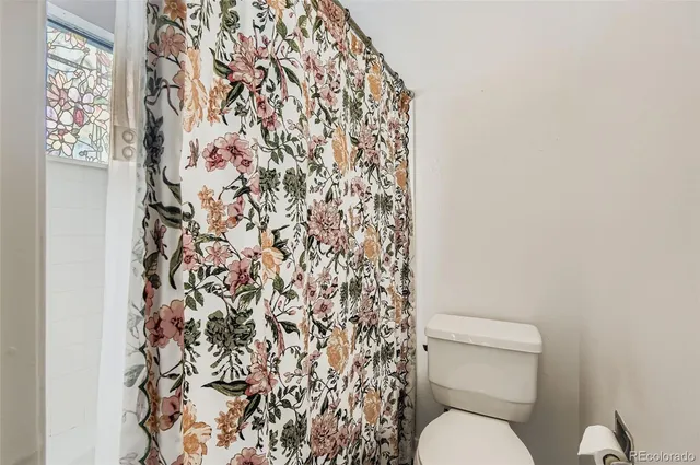 a white toilet sitting next to a shower curtain