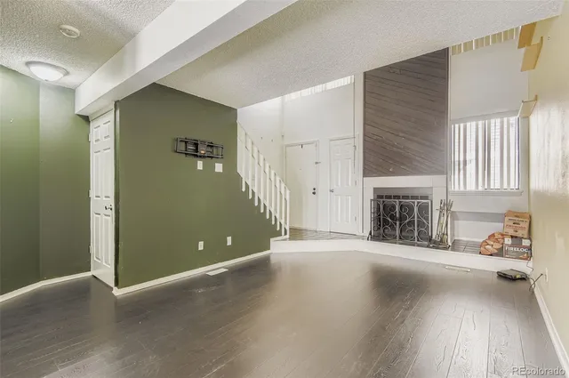 an empty room with windows and fireplace