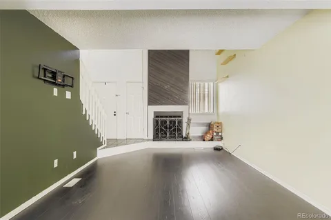 a view of a livingroom with wooden floor and a fireplace