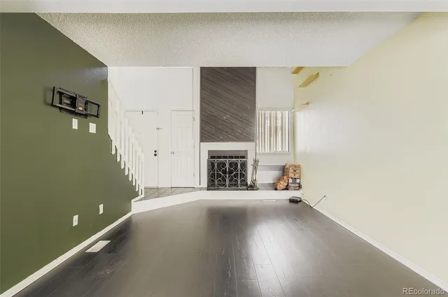 a view of a livingroom with wooden floor and a fireplace
