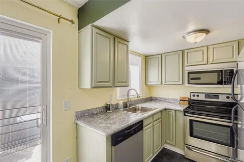 a kitchen with stainless steel appliances granite countertop a sink and a stove