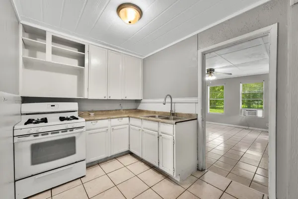 a kitchen with a stove sink and cabinets