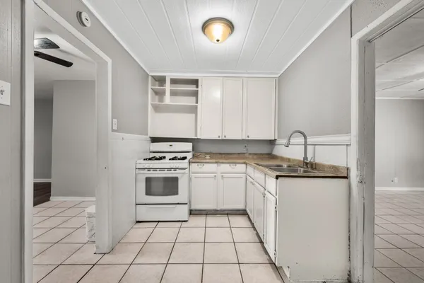 a kitchen with a stove sink and cabinets