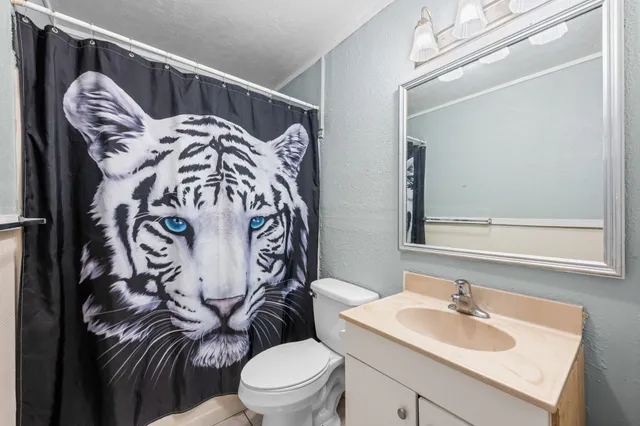 a bathroom with a sink and mirror with toilet