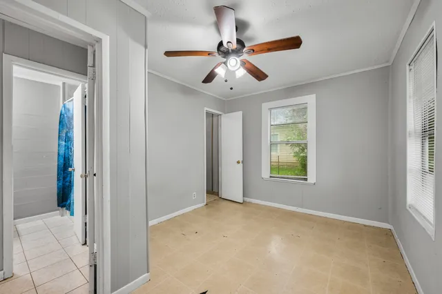 a view of an empty room and window and a ceiling fan