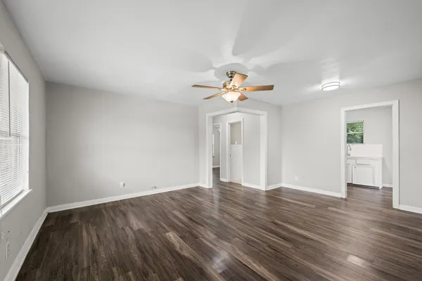 an empty room with wooden floor and windows