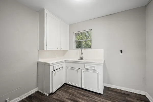 a room with a sink cabinets and wooden floor