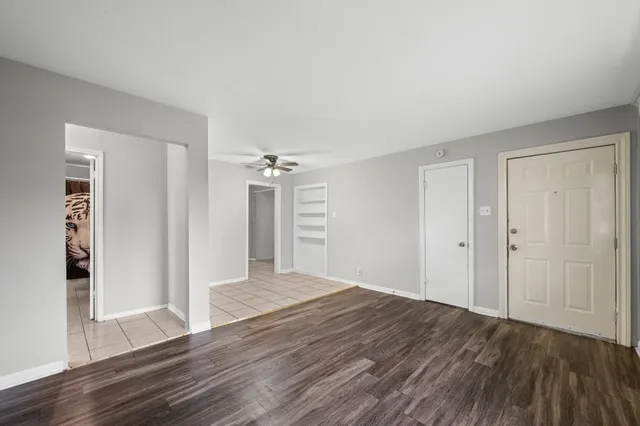 a view of a room with wooden floor and entryway