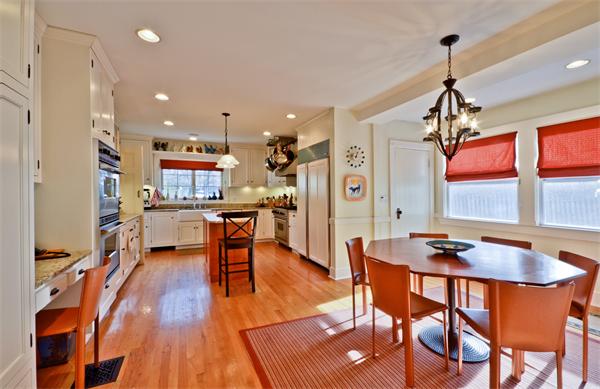 18 Willard Road Brookline, MA 02445 - Photo 4 of 14 a dining room with stainless steel appliances kitchen island granite countertop wooden floor a dining table and chairs