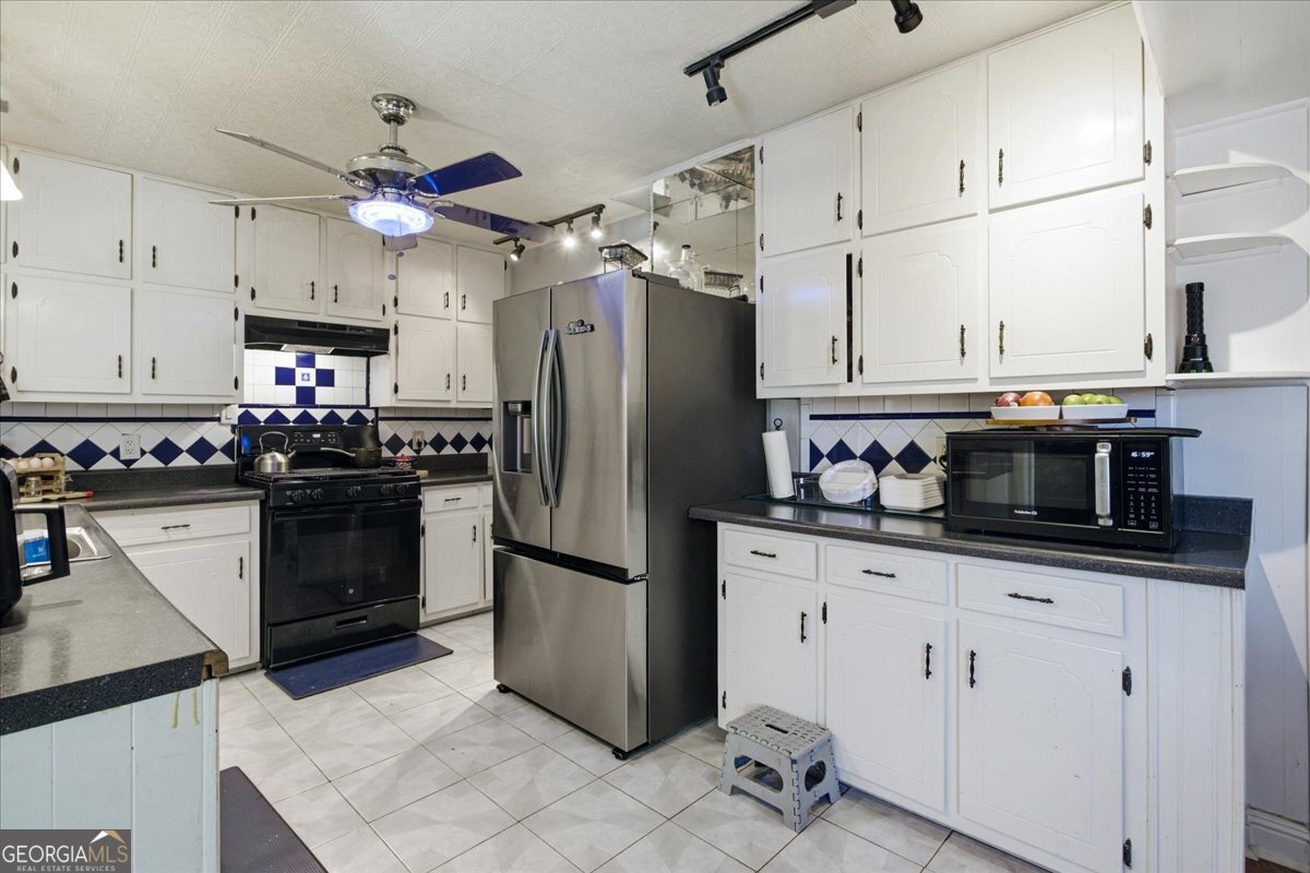 3270 Rex Road Rex, GA 30273 - Photo 10 of 35 a kitchen with stainless steel appliances granite countertop a refrigerator a stove a sink dishwasher and a refrigerator with white cabinets