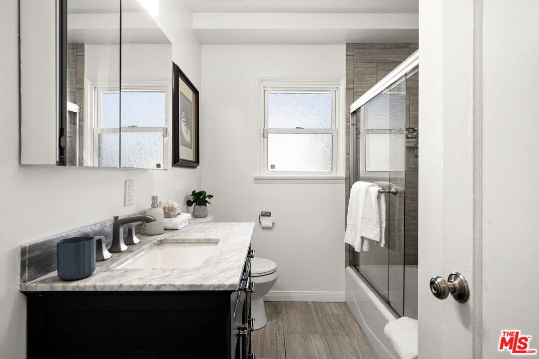 3770 Buckingham Road Los Angeles, CA 90016 - Photo 12 of 19 a en suite bathroom with a granite countertop sink and a mirror