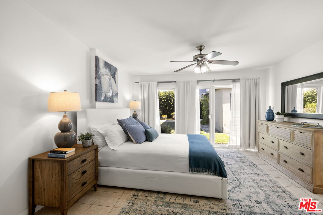 3770 Buckingham Road Los Angeles, CA 90016 - Photo 13 of 19 a bedroom with a large bed and a flat tv screen on dresser