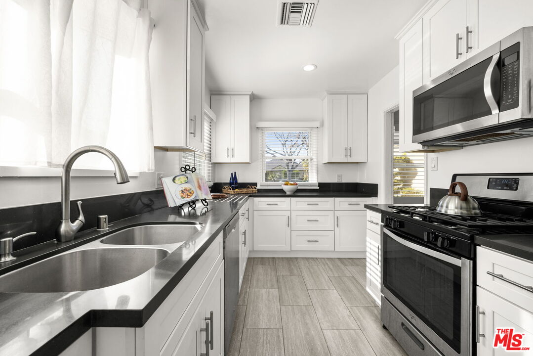 3770 Buckingham Road Los Angeles, CA 90016 - Photo 5 of 19 a kitchen with granite countertop a sink a stove and cabinets