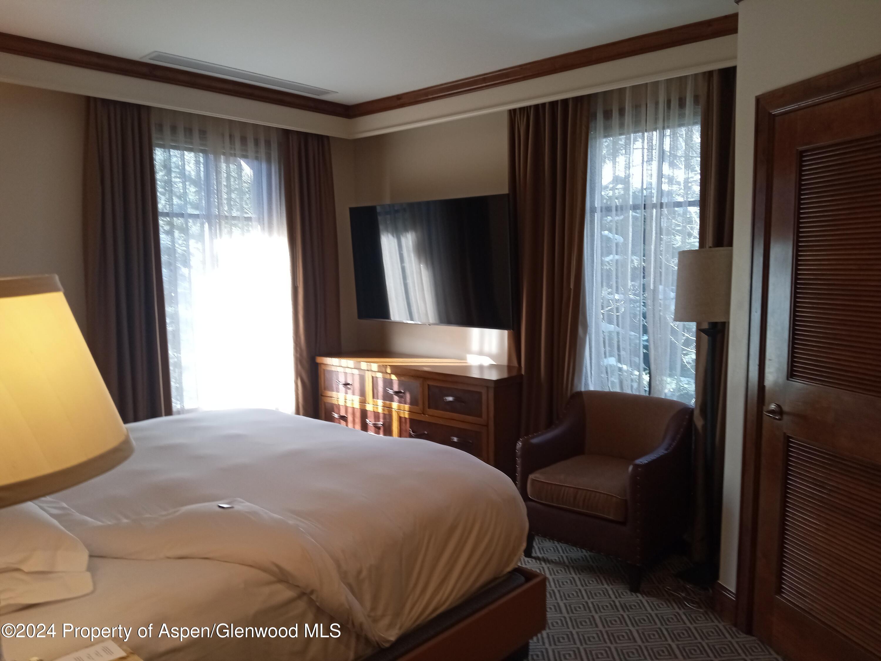 75 Prospector Road, Unit 8206 SUMMER INTEREST 7 Aspen, CO 81611 - Photo 7 of 21 a bedroom with a bed and wooden floor