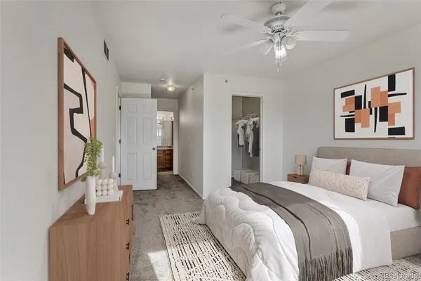 a spacious bedroom with a bed and a chandelier