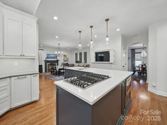 a kitchen with stainless steel appliances granite countertop a stove top oven a sink dishwasher and cabinets with wooden floor
