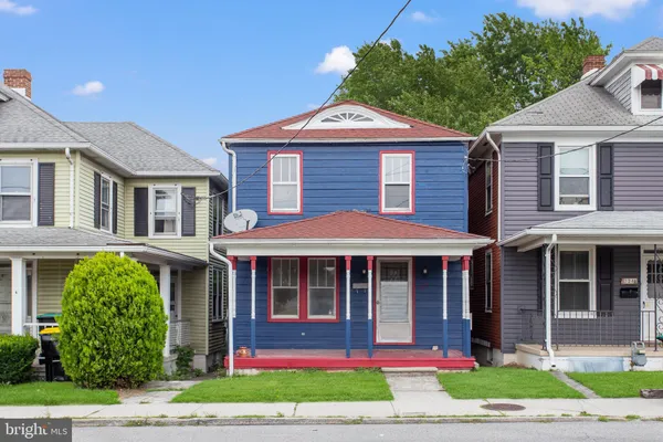a front view of a house with a yard and potted plants
