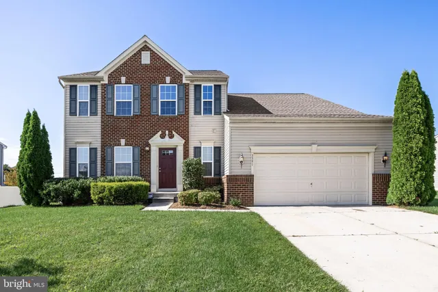 a front view of a house with a garden and plants