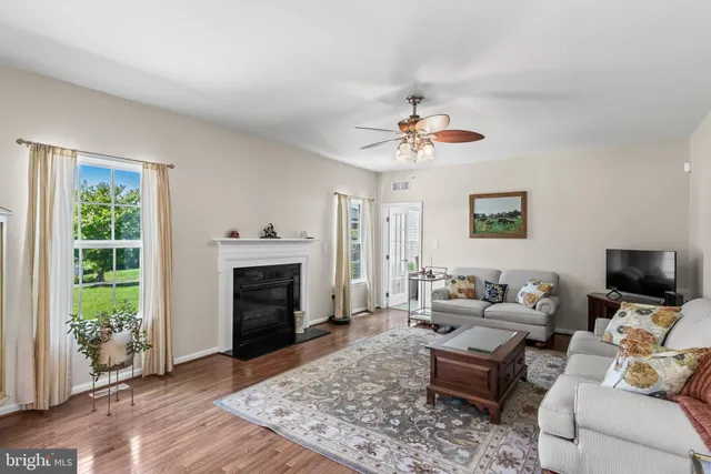 a living room with furniture kitchen view and a chandelier