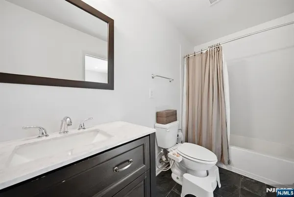 a bathroom with a sink a toilet a mirror and shower