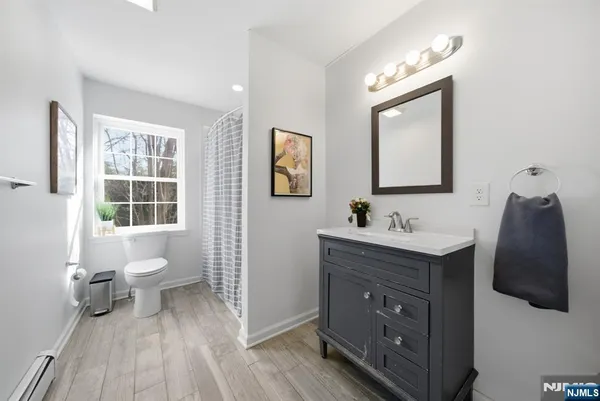 a bathroom with a toilet sink double vanity and mirror