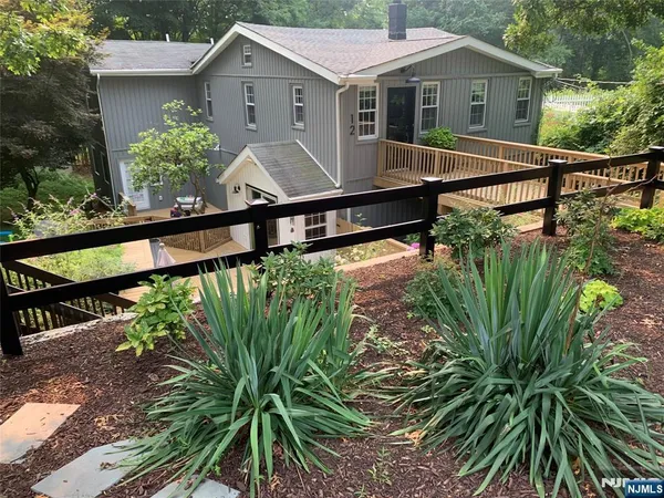 a view of a house with wooden fence next to a yard