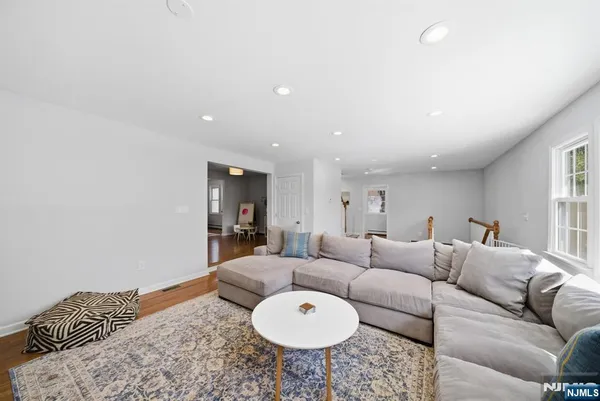 a living room with furniture a rug and wall painting