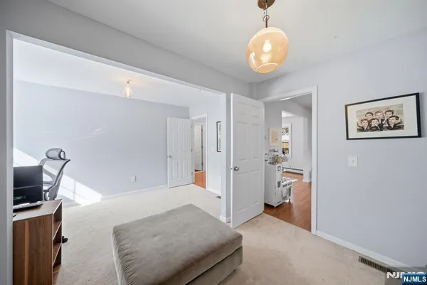 a spacious bedroom with a bed and a chandelier