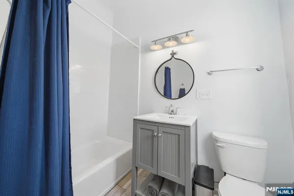 a bathroom with a toilet sink vanity tub and mirror