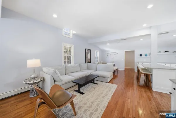 a living room with furniture a wooden floor and a lamp